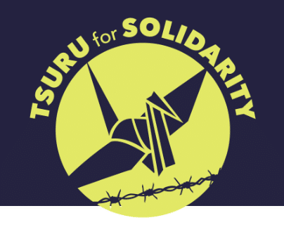 A paper crane soars over barbed wire with Tsuru for Solidarity over it